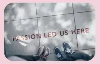 Passion led us here written on a sidewalk with people's feet next to it.