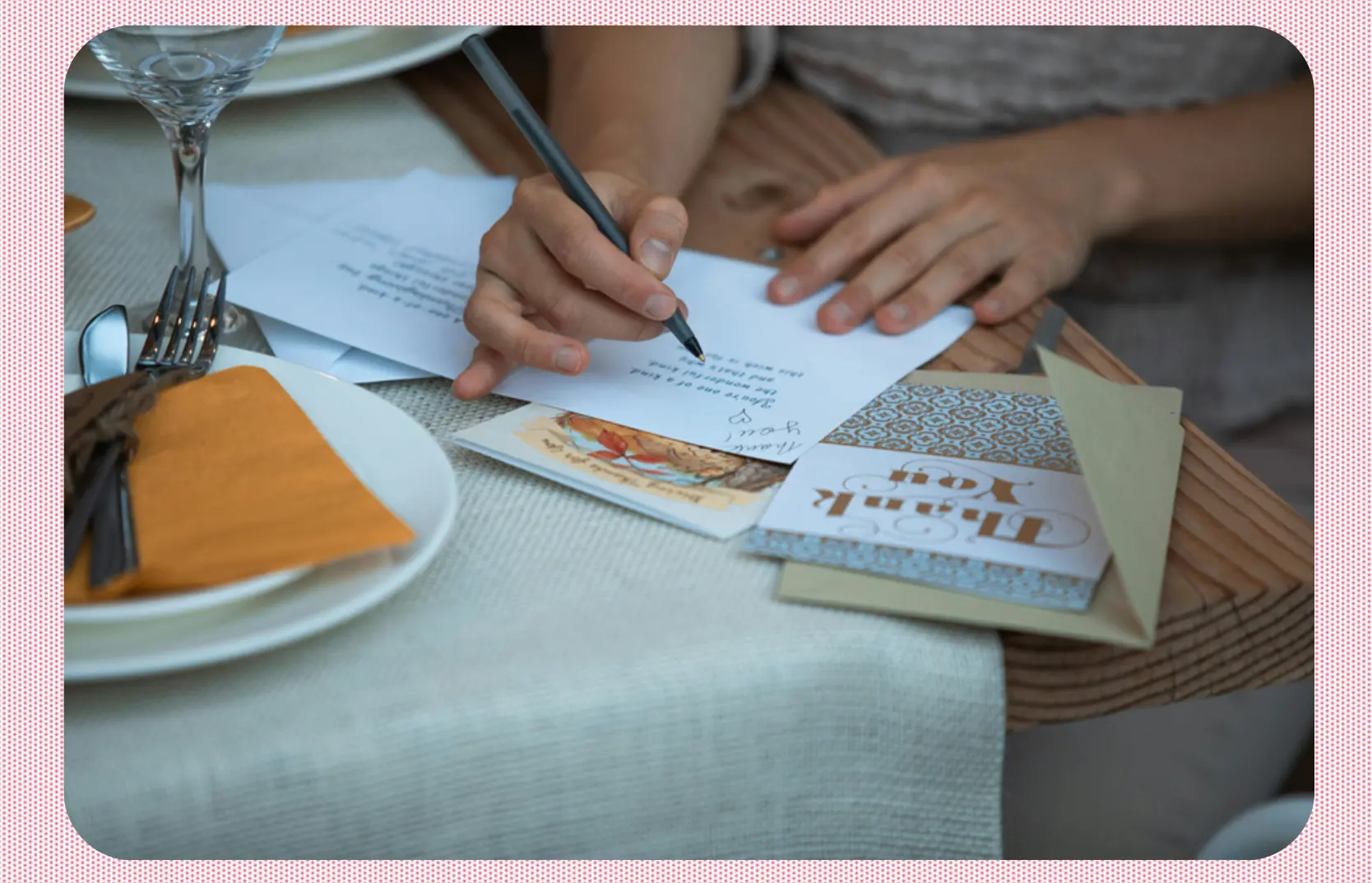 A close up photo of someone writing in a Thank You card