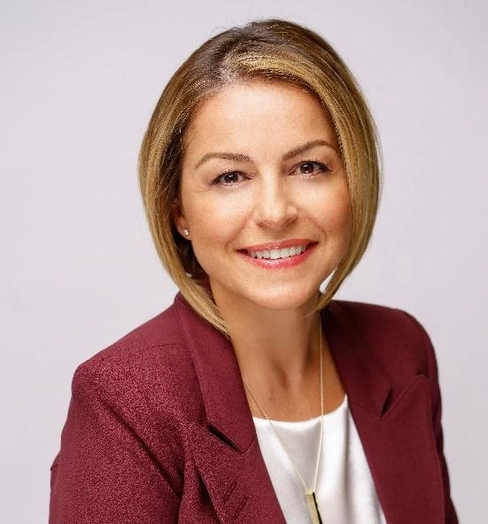 Photo of Snezana Stefanovic a middle-aged female professional with blonde hair and smile in a marroon suit